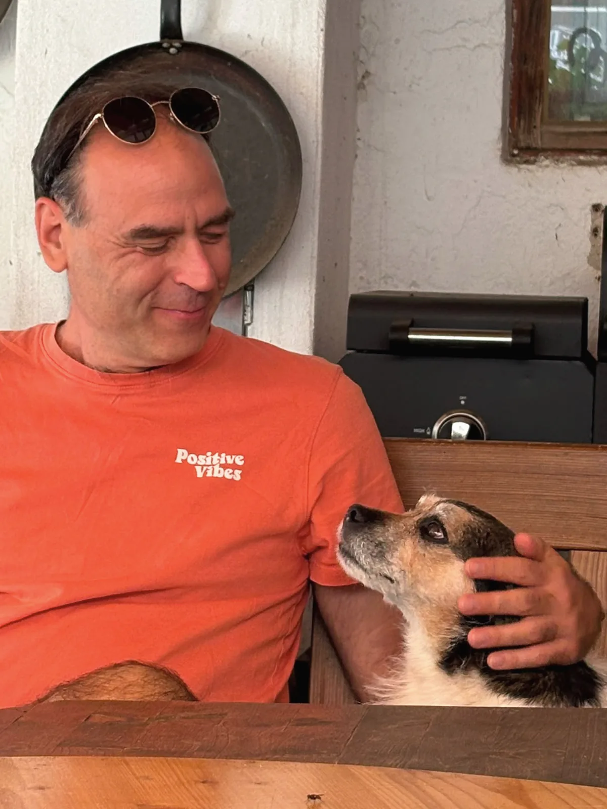 Balazs Abraham in einer Küche, im Gespräch mit seinem Hund, der zu ihm aufsieht.